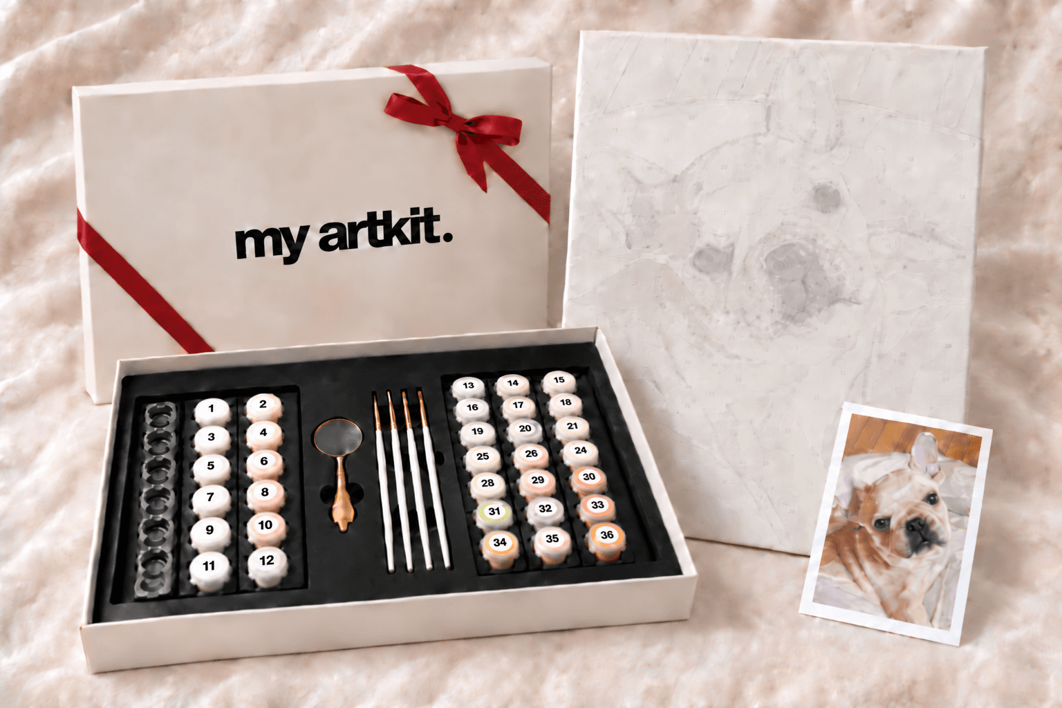 フレンチブルドッグの番号付き下絵、絵の具・筆・ルーペと赤いリボンのギフトBOXを並べたキットの内容例